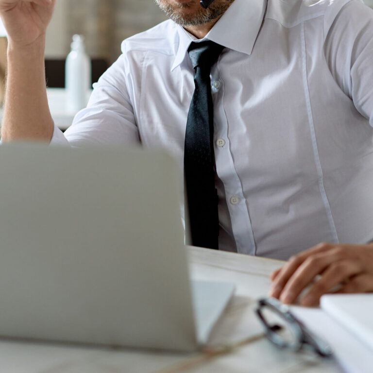 Mid adult businessman wearing headphones while having video call - G Construction